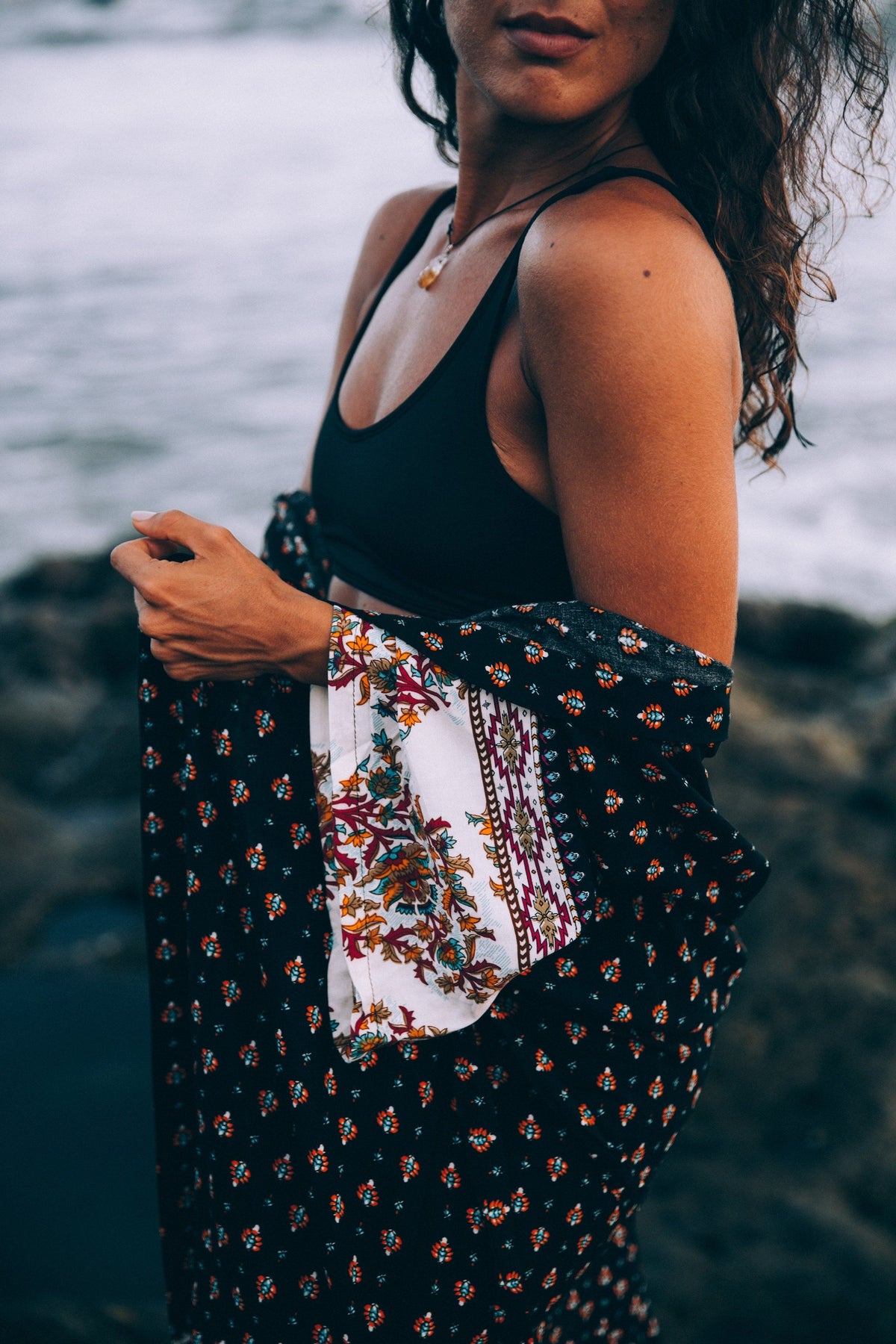 Floral beach wrap robe, independent photograph 3; styling props excluded. Photo: Brodie; Shopify Burst a-woman-by-the-sea-with-patterned-shawl-draped-through-arms; Burst Some Rights Reserved. Editorial demo, not manufacturer endorsement.