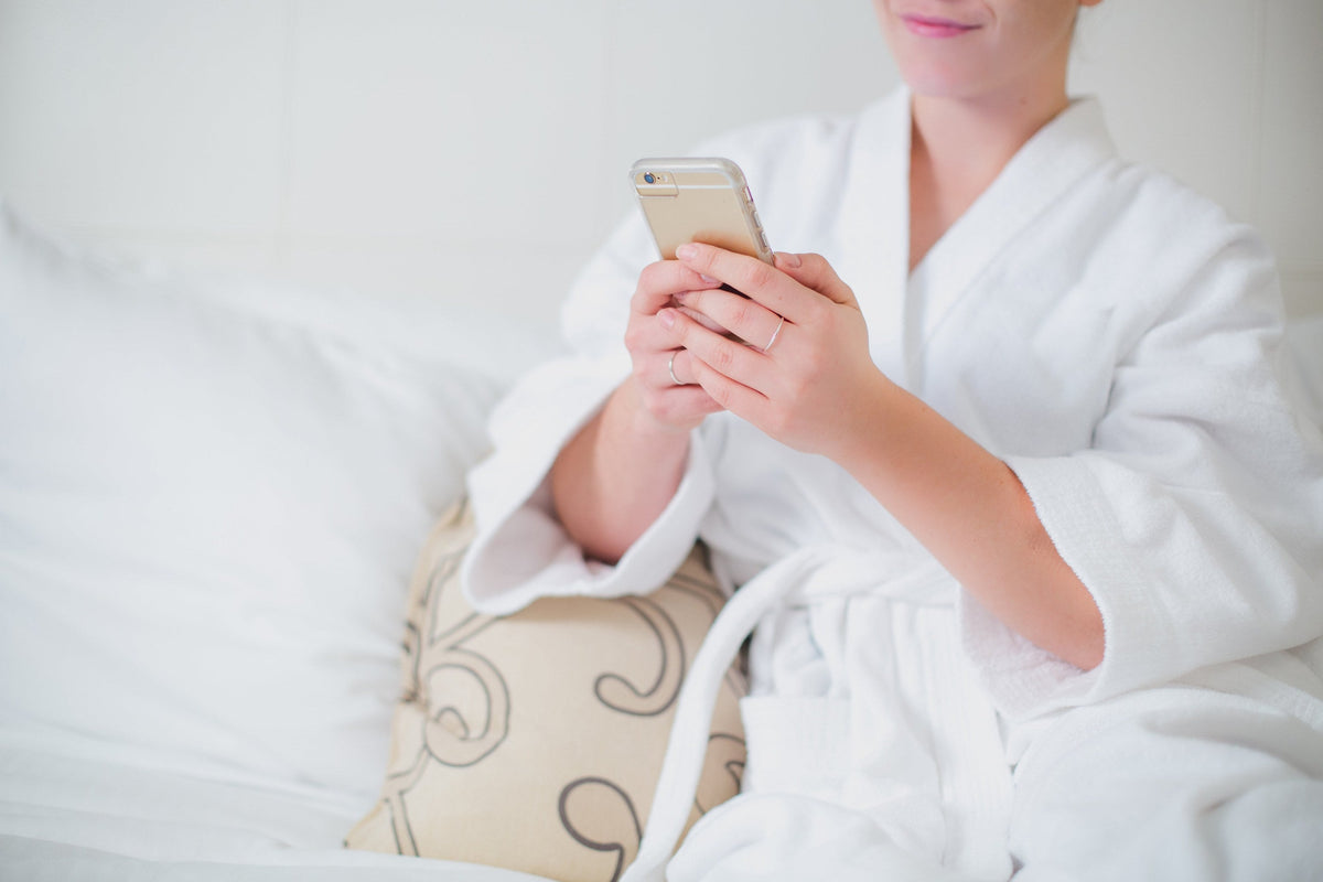 White hotel wrap robe, independent photograph 1; styling props excluded. Photo: Shopify Partners; Shopify Burst woman-lounges-in-bathrobe-with-phone; Burst Some Rights Reserved. Editorial demo, not manufacturer endorsement.