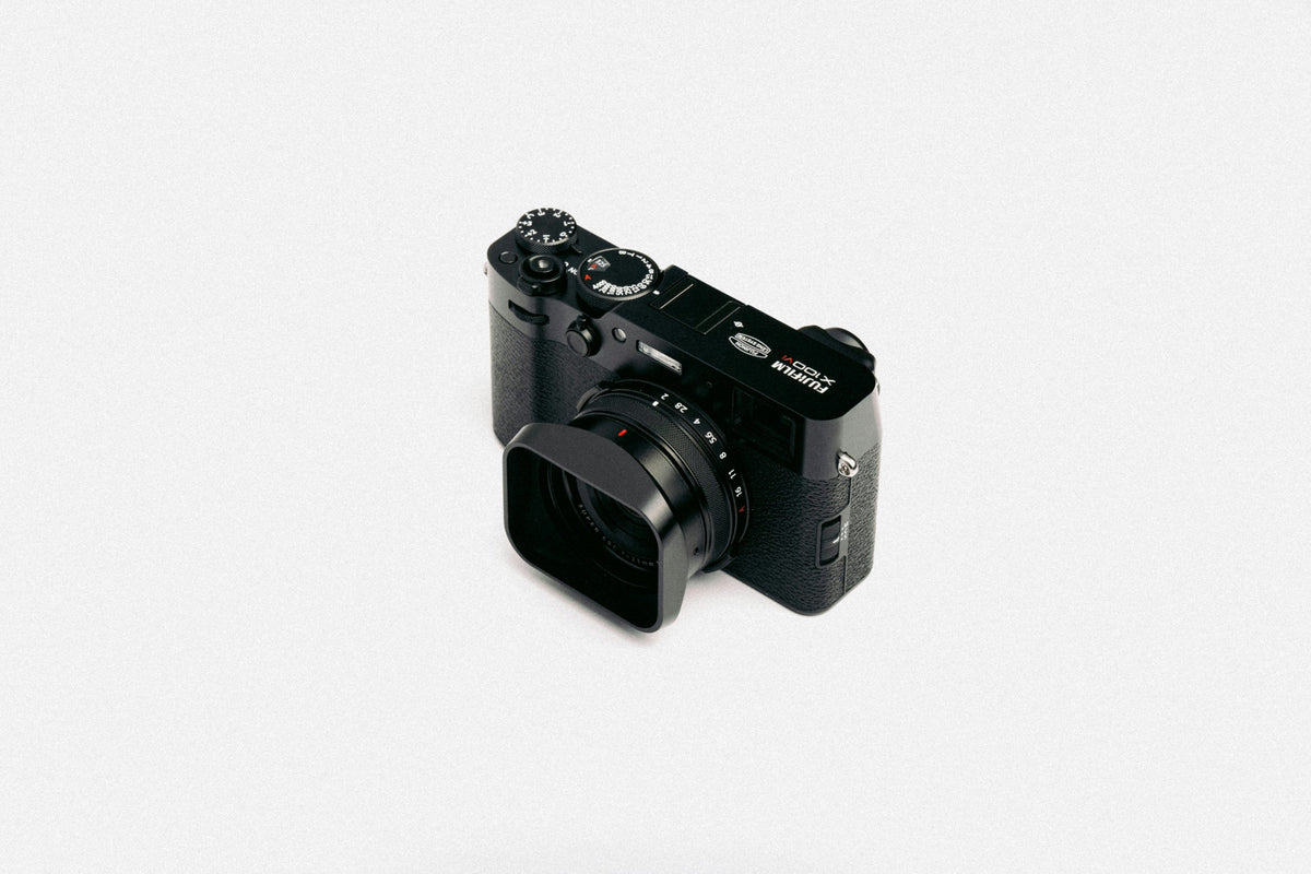 Black Compact Camera — photograph 1. Photo: Howard Bouchevereau; https://unsplash.com/photos/a-black-camera-sitting-on-top-of-a-white-table-51ukFyEwUQk. Photographic demo.