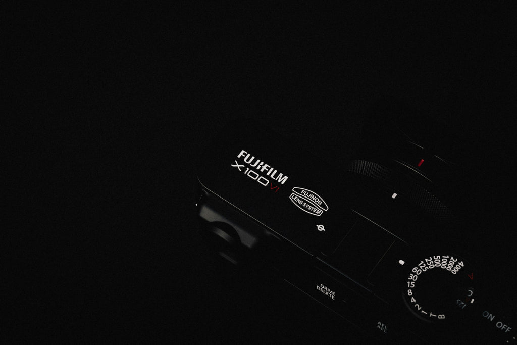 Black Compact Camera — photograph 3. Photo: Howard Bouchevereau; https://unsplash.com/photos/a-close-up-of-a-camera-in-the-dark-P-0MFhdiJxU. Photographic demo.