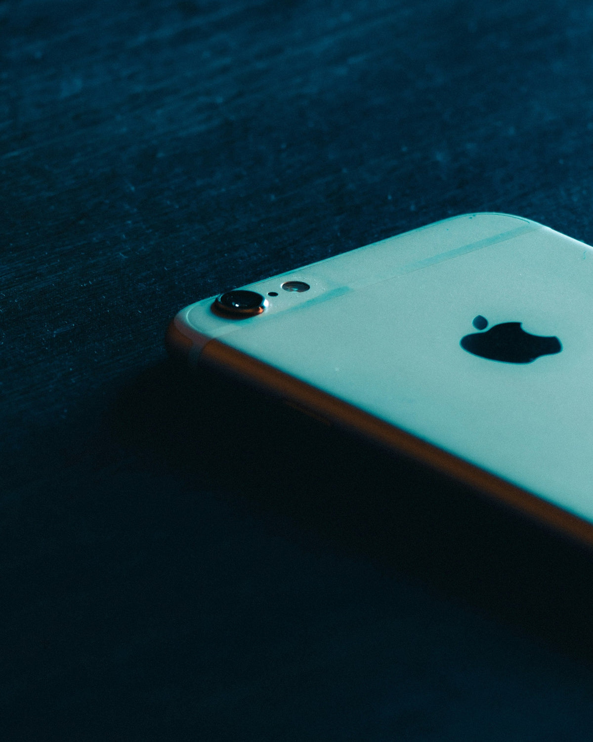 Rose Metal Phone — Photographic Demo — photograph 3. Photo: Luis Felipe Lins; https://unsplash.com/photos/gold-iphone-6-on-black-wooden-table-M19H_I13iWo. Photographic demo.