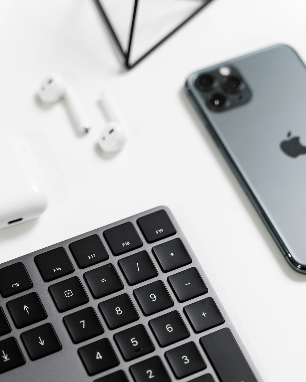 White Stem Earbuds — Photographic Demo — photograph 3. Photo: AltumCode; https://unsplash.com/photos/an-iphone-ear-buds-and-a-keyboard-on-a-table-mNAETd-1ypk. Photographic demo.