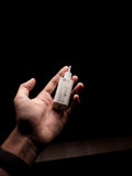 Compact white wall charger held in an open hand against a dark background