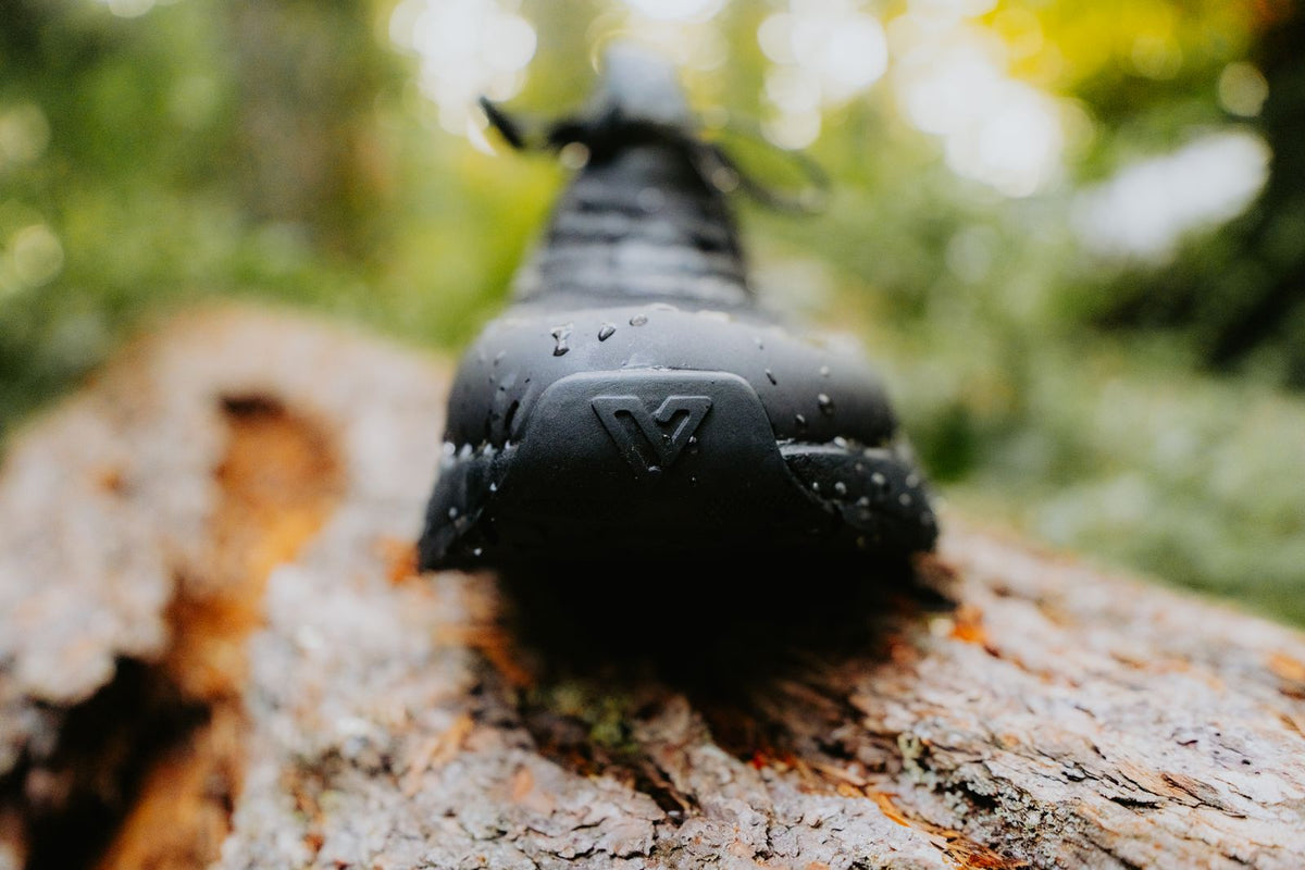 Trail Ridge rubber lug outsole seen from below, shoe resting on a tree stump