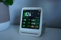 Small white indoor air quality monitor on a table