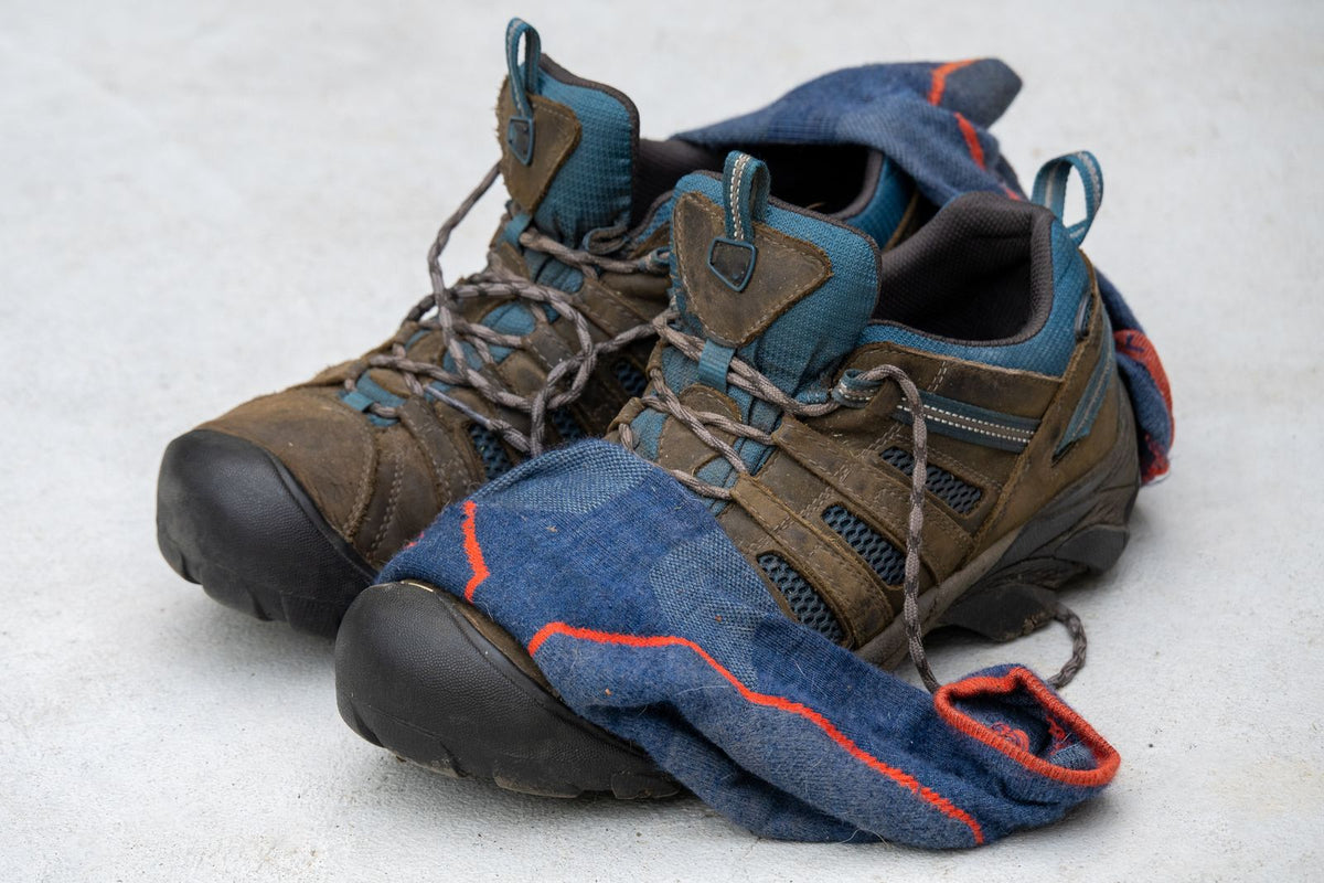 Trail Low in Clay — pair of brown low-cut hiking shoes with wool socks on a light backdrop