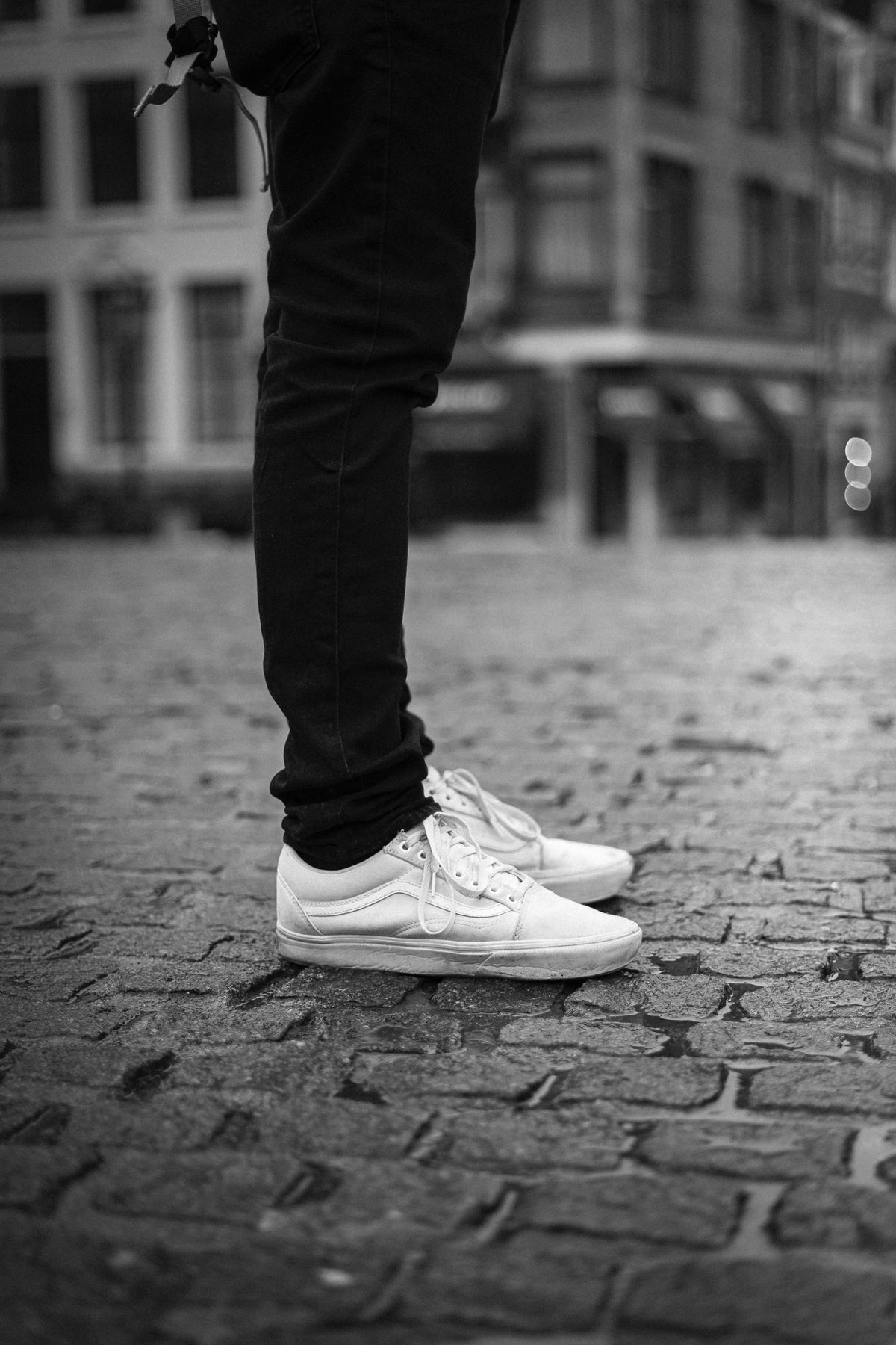 City Court sneakers worn with cropped black trousers on a cobbled European street