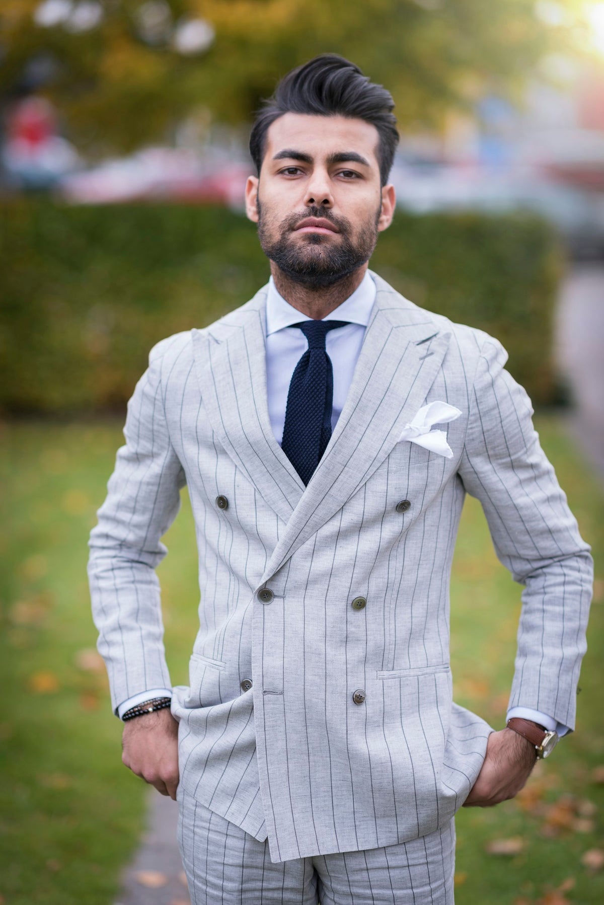 Man wearing a double-breasted pinstripe blazer outdoors in natural light