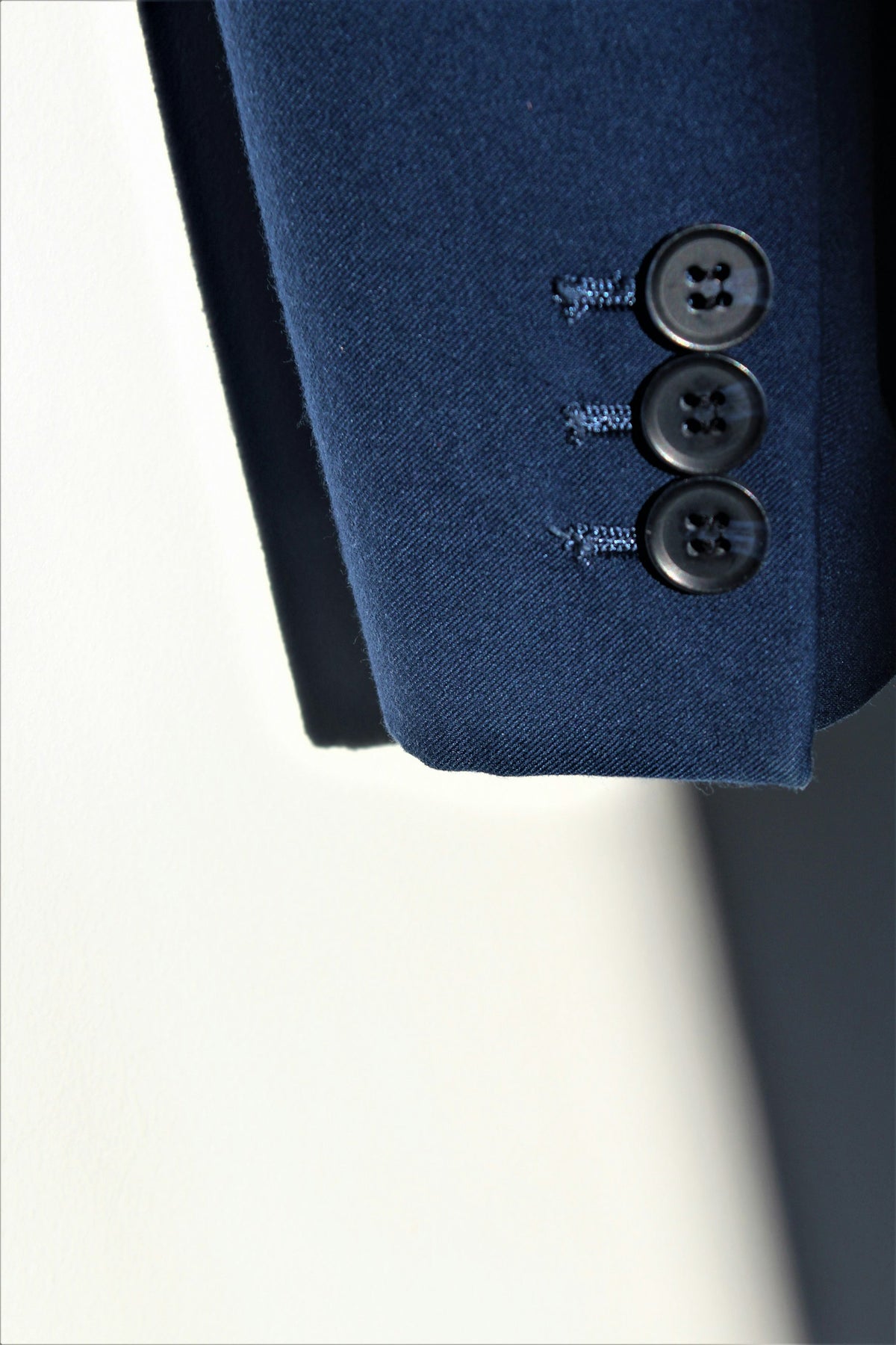 Detail of buttons on a navy blazer sleeve cuff