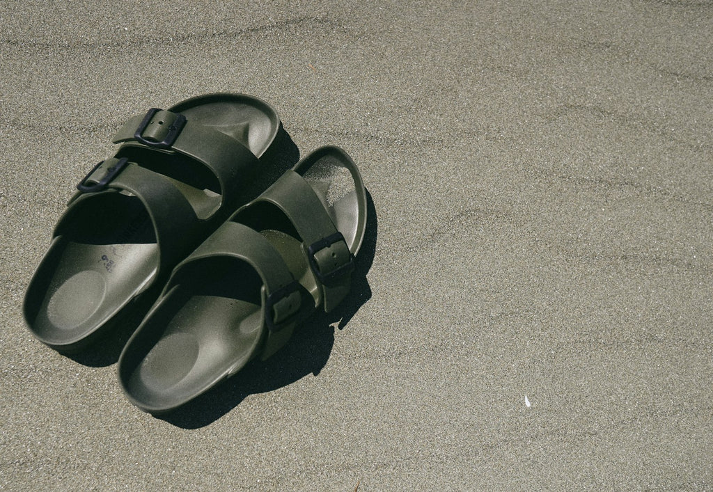 Pair of black Everyday Slides seen from above on sand