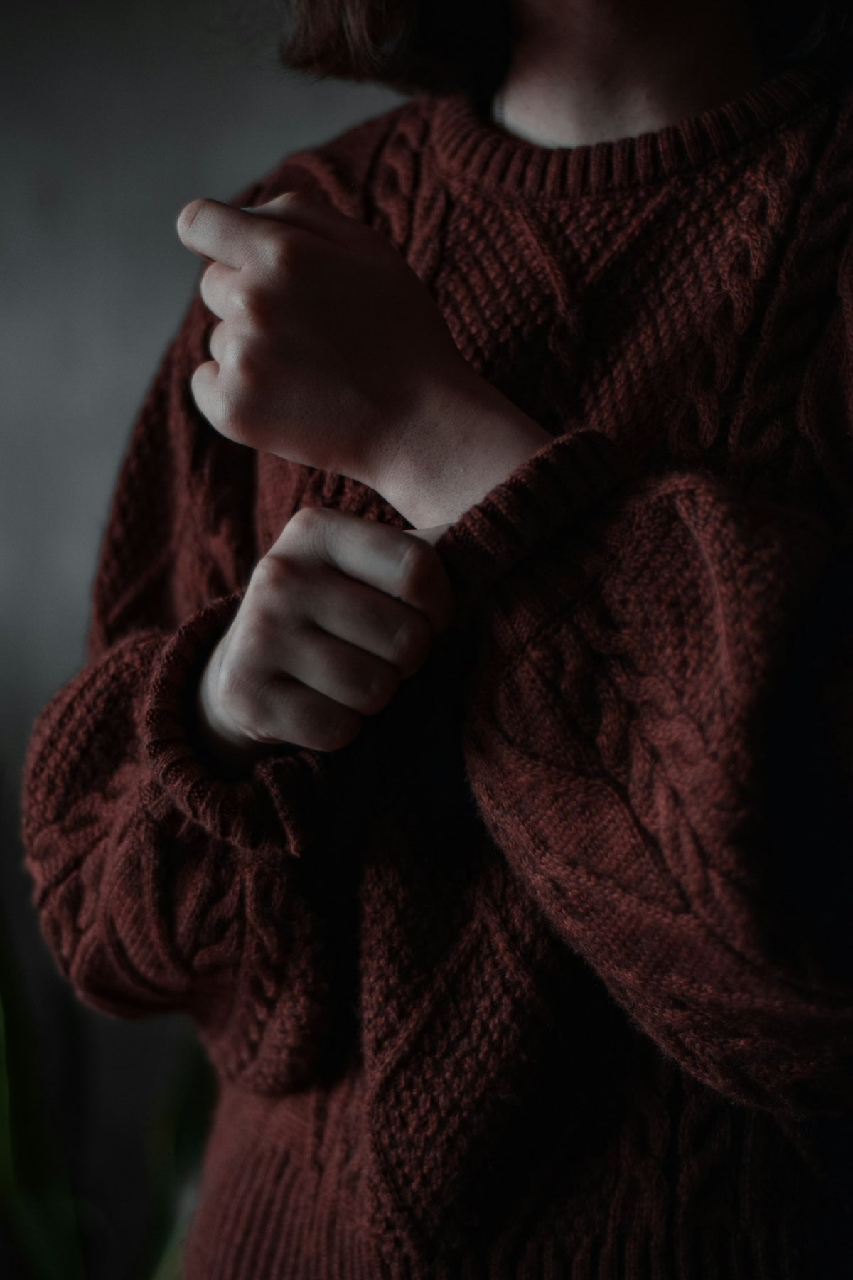 Detail of a bordeaux knit sweater sleeve