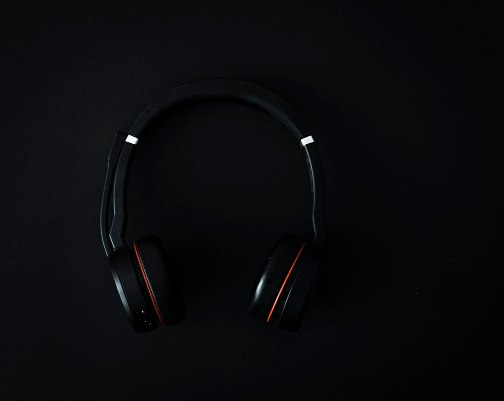 Black over-ear wireless headphones on a dark studio surface