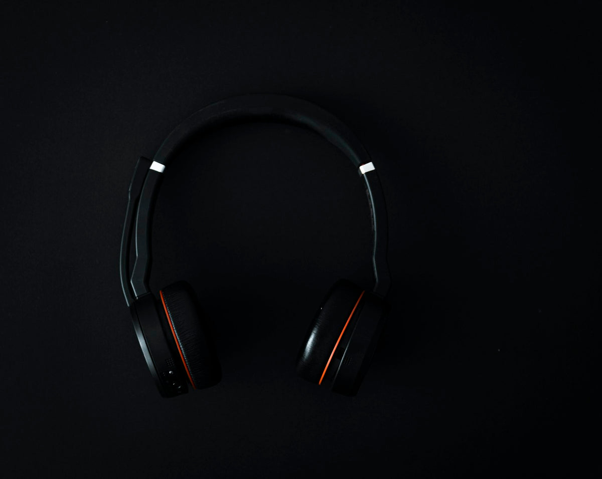 Black over-ear wireless headphones on a dark studio surface