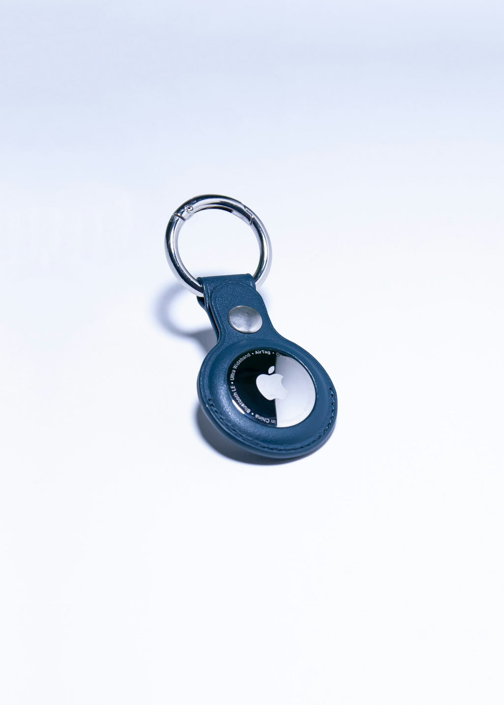 Item tracker in a leather key-ring holder on a light surface