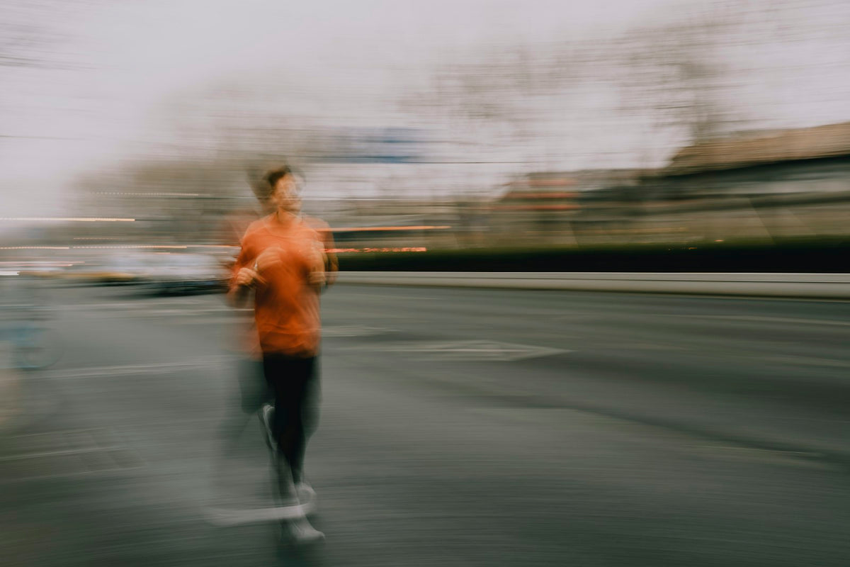 Runner in Road Glide shoes mid-stride on a city street at dawn, slight motion blur