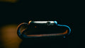 Smartwatch with a textured strap lying on a dark surface under rim light