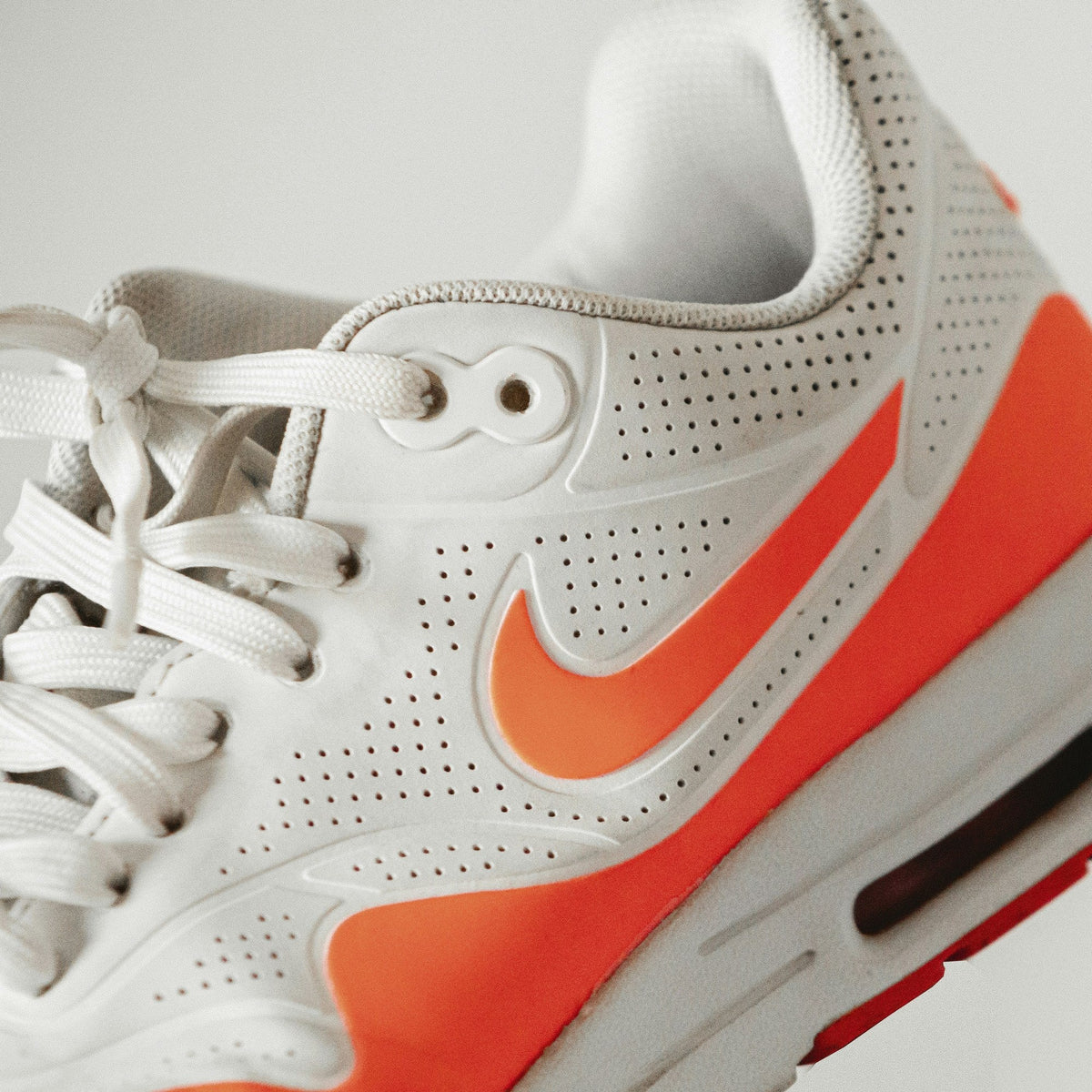 White Orange Air Cushion — Photographic Demo — photograph 1. Photo: Luis Felipe Lins; https://unsplash.com/photos/white-red-and-black-nike-air-max-8T-LD_wxlSo. Photographic demo.