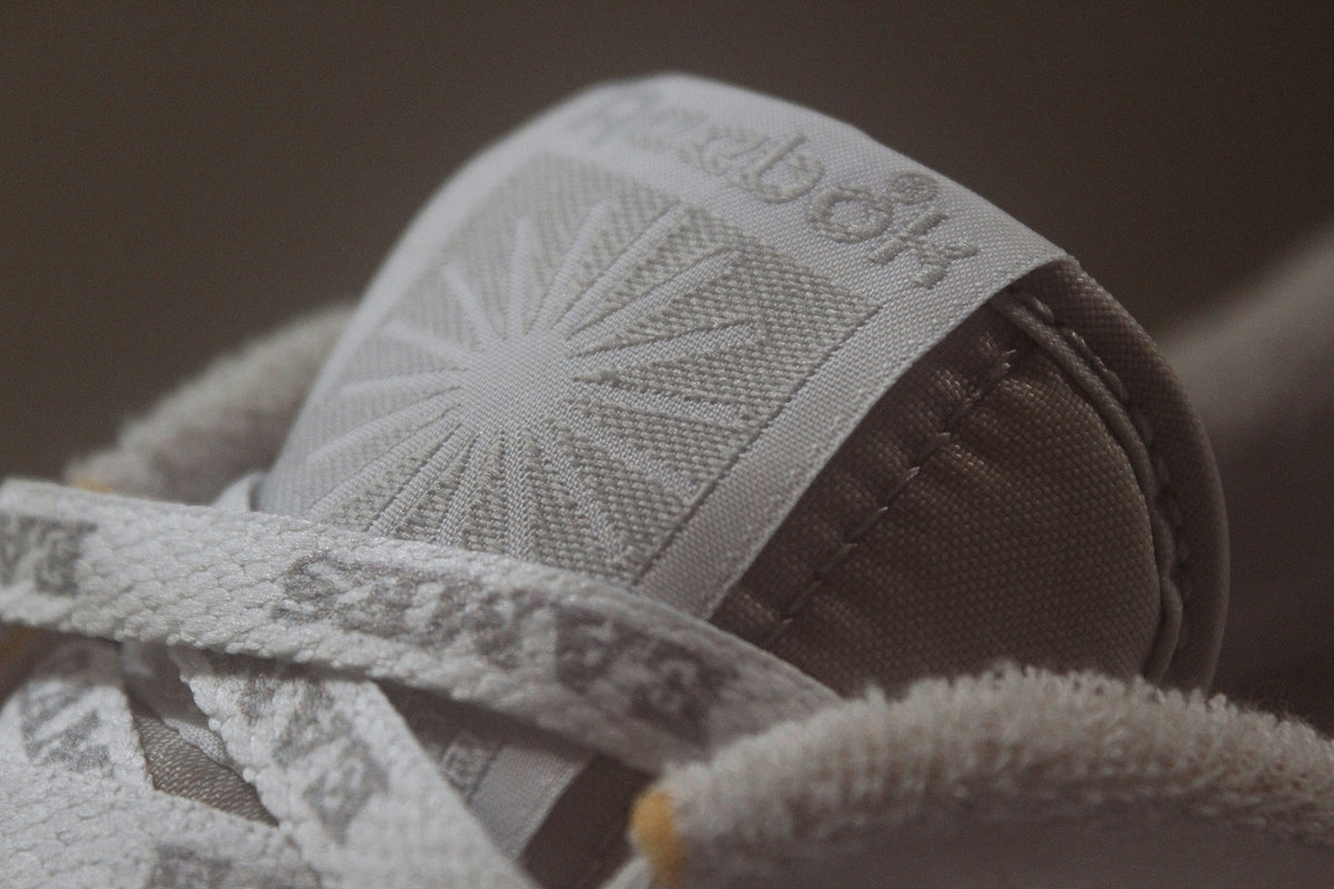 White Stitched Low Top — Photographic Demo — photograph 3. Photo: @felirbe; https://unsplash.com/photos/a-close-up-of-a-pair-of-sneakers-NRbRBTjqpaQ. Photographic demo.